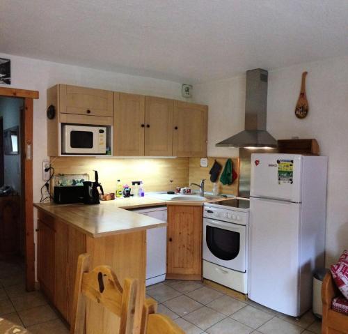 une cuisine avec des appareils électroménagers blancs et des armoires en bois dans l'établissement Résidence Les Bergers - 3 pièces cabine 6 personnes 3 expo est MAE-4114, à Valloire