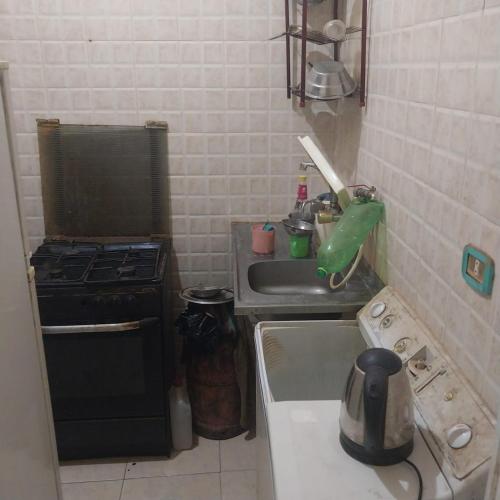 uma pequena cozinha com um fogão e um lavatório em Adel Hotel em Abu Simbel