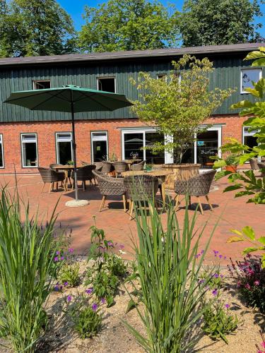 a patio with tables and chairs and an umbrella at Tipi Wappo in Belau