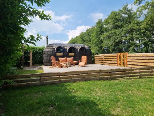 a backyard patio with furniture and a wooden fence at Tipi Wappo in Belau