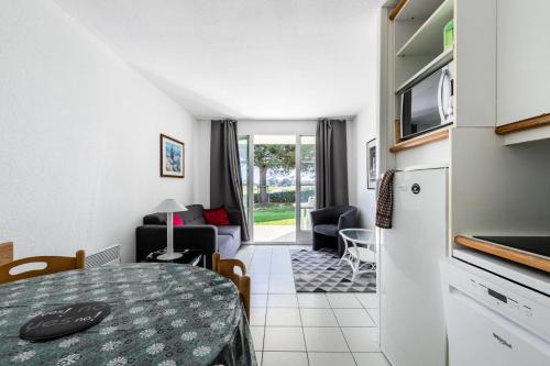 een keuken en een woonkamer met een tafel bij Résidence Port Bourgenay - maeva Home - Appartement 2 pièces 4 personnes - 434 in Talmont