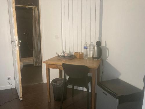 - une petite table en bois avec une chaise dans l'établissement Chambre Quadruple Avec 4 Couchages - Proche Disneyland Paris, à Mareuil-lès-Meaux
