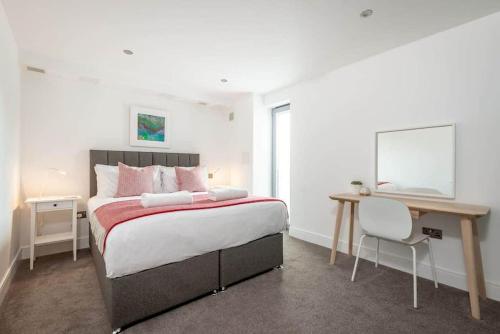 um quarto com uma cama grande e uma secretária. em Luxury Garden Apartment in St Andrews em St. Andrews