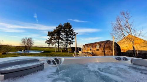 uma banheira de hidromassagem com neve em frente a um celeiro em Igluhut Molendini em Püchau