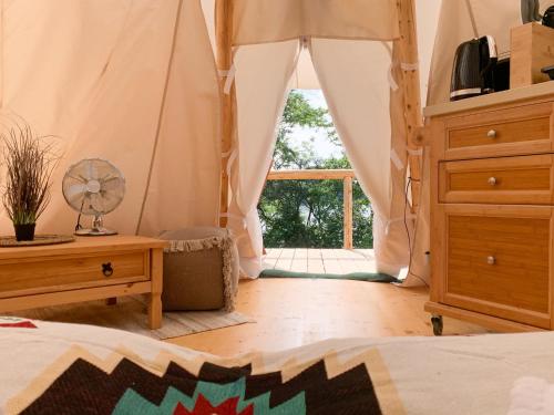 a bedroom with a bed and a large window at Tipi Kiowa in Belau
