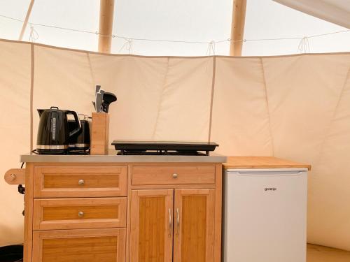 a kitchen with a wooden cabinet and a table at Tipi Blackfoot in Belau