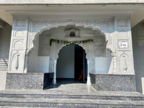 einen Eingang zu einem weißen Gebäude mit einer Treppe in der Unterkunft Hello Namaste India - Elite in Jaipur