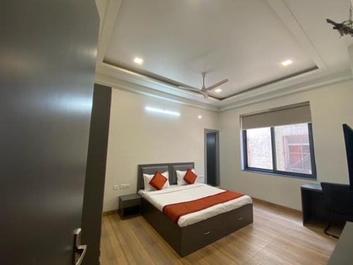 Schlafzimmer mit einem Bett, einem Schreibtisch und einem Fenster in der Unterkunft Hello Namaste India - Elite in Jaipur
