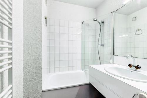 une salle de bain blanche avec un lavabo et une douche dans l'établissement Résidence Port Bourgenay - maeva Home - Appartement 2 pièces 5 personnes - Sélection MAE-0984, à Talmont-Saint-Hilaire