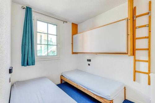 une petite chambre avec deux lits et une fenêtre dans l'établissement Résidence Port Bourgenay - maeva Home - Appartement 2 pièces 5 personnes - Sélection MAE-0984, à Talmont-Saint-Hilaire