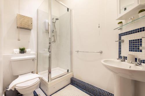 a bathroom with a shower and a toilet and a sink at The Whitecross Street Collection in London