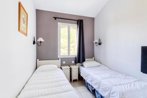 zwei Betten in einem Zimmer mit Fenster in der Unterkunft Les maisons Le Rouret - maeva Home - Maison 3 pièces 6 personnes - Prestige MAE-1044 in Grospierres