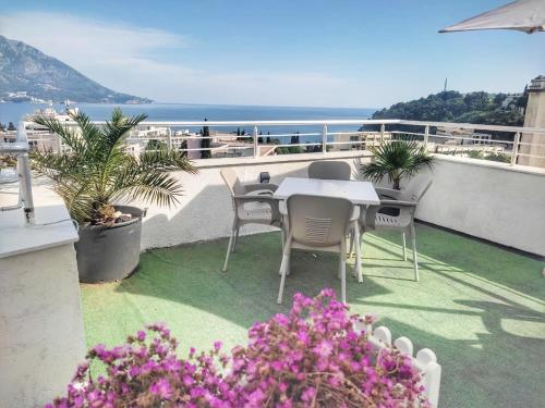 a table and chairs on a balcony with a view of the ocean at Apartments Mitende in Budva