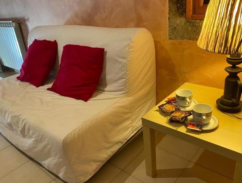 a bed with two red pillows and a table at La dimora nel castello in Bomarzo