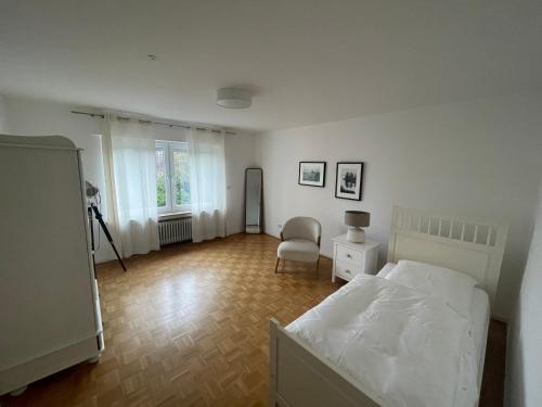 um quarto com uma cama e uma cadeira em Ferienwohnung Wohnung Krefeld Forstwald Höltehoffe em Krefeld