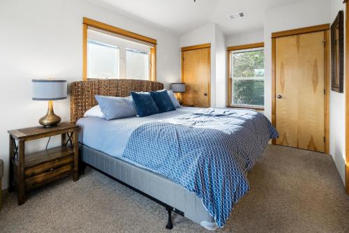 1 dormitorio con 1 cama con edredón azul y ventana en Pioneer Vacation Rentals - Pioneer Craftsman House, en Ashland