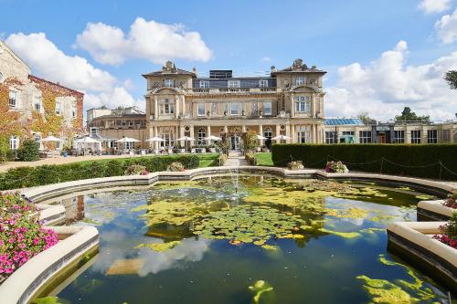 una casa grande con un estanque frente a ella en Down Hall Hotel en Bishops Stortford