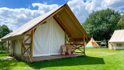 a large canvas tent with chairs in a field at Safarizelt Simba in Falkenberg