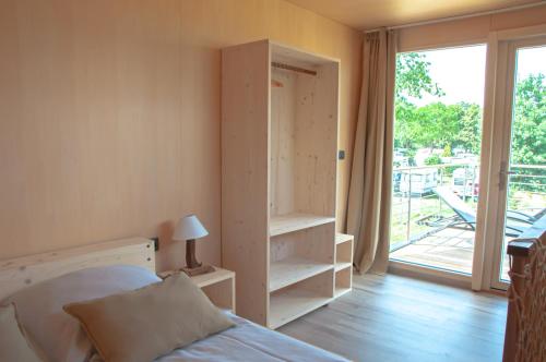a bedroom with a bed and a door to a balcony at Haus Frau Elster in Falkenberg