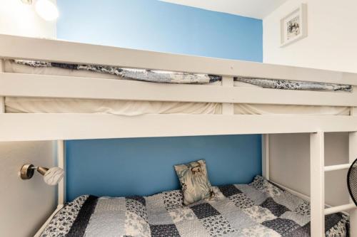 Ce lit superposé se trouve dans une chambre pour enfants dotée d'un mur bleu. dans l'établissement Village Pont Royal en Provence - maeva Home - Appartement décoré avec goût et climatisé 3 pièces 4 personnes - Prestige - super Home MAE-1144, à Mallemort
