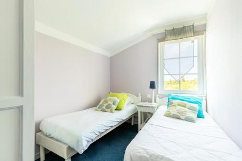 twee bedden in een kamer met een raam bij Les Maisons de Port Bourgenay - maeva Home - Maison 3 pièces 6 personnes - 954 in Talmont