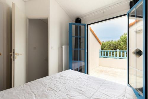 une chambre avec un lit et une grande fenêtre dans l'établissement Résidence Port Bourgenay - maeva Home - Appartement 2 pièces 4 personnes - Sélection MAE-2244, à Talmont-Saint-Hilaire