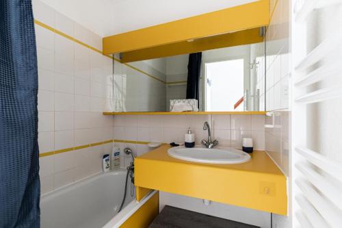 une salle de bain avec un lavabo, un miroir et une baignoire dans l'établissement Résidence Port Bourgenay - maeva Home - Appartement 2 pièces 4 personnes - Sélection MAE-2244, à Talmont-Saint-Hilaire