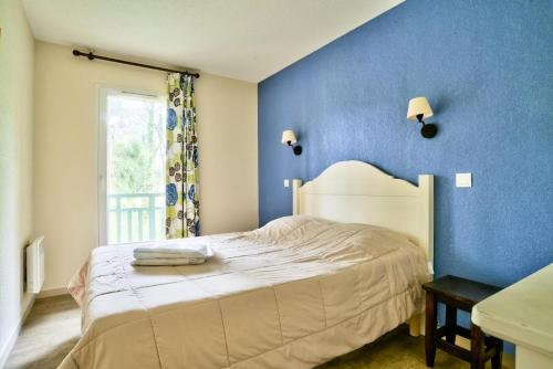 niebieska sypialnia z łóżkiem i oknem w obiekcie Les Maisons du Domaine du Golf de Pinsolle - maeva Home - Maison 3 pièces 6 personnes - Sélection MAE-9964 w mieście Soustons