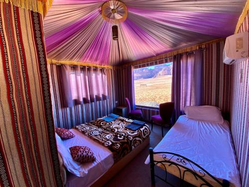 a bedroom with a tent with a bed and a window at Rum Marriott luxury camp in Wadi Rum