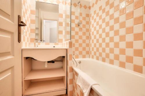 une salle de bain avec un lavabo, une baignoire et un miroir dans l'établissement Résidence Cannes Villa Francia - maeva Home - Appartement 3 pièces 7 personnes - Sélection MAE-0244, à Cannes