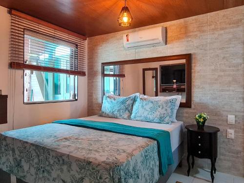 a bedroom with a bed and a mirror at Estada Inesquecível 17 Guarapari in Guarapari