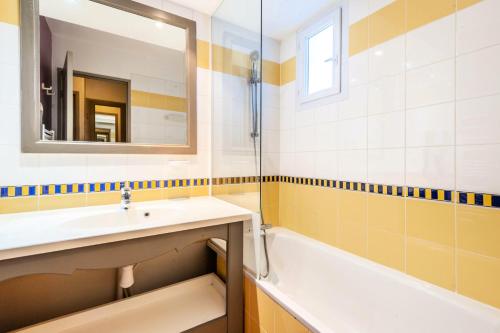 y baño con lavabo, bañera y espejo. en Hôtel du Golf de Pont Royal - maeva Home - Appartement 2 pièces 4 personne 114, en Mallemort