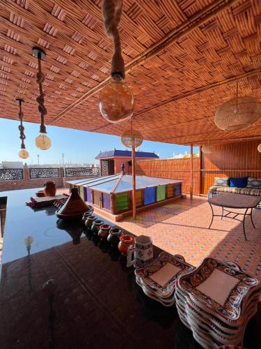 un patio con sillas, una mesa y agua en Riad el wazania en Rabat