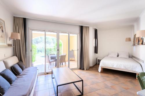 un salon avec un canapé et un lit dans l'établissement Village Pont Royal en Provence - maeva Home - Studio 5 personnes - Sélection MAE-2824, à Mallemort
