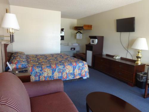 a hotel room with a bed and a couch at National 9 Inn in Garden City