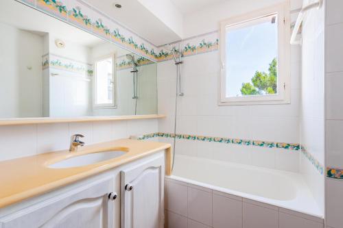 a bathroom with a sink and a tub and a window at Les maisons et villas de Pont Royal en Provence - maeva Home - Maison 4 piè 124 in Mallemort