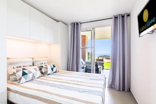 une chambre avec un lit et une porte coulissante en verre dans l'établissement Résidence le Village de Cap Esterel - maeva Home - Appartement moderne 2 pièces 4 personnes - Prestige - super Home MAE-4494, à Saint-Raphaël