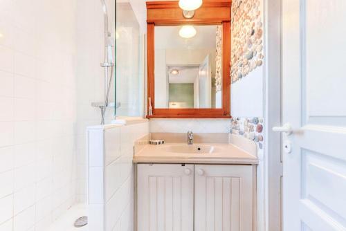 une salle de bain avec un lavabo et un miroir dans l'établissement Les Maisons de Lacanau les Pins - maeva Home - Maison 3 pièces 5 personnes - Prestige MAE-9674, à Lacanau