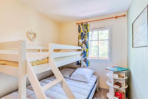 une chambre avec deux lits superposés et une fenêtre dans l'établissement Les Maisons de Lacanau les Pins - maeva Home - Maison 3 pièces 5 personnes - Prestige MAE-9674, à Lacanau