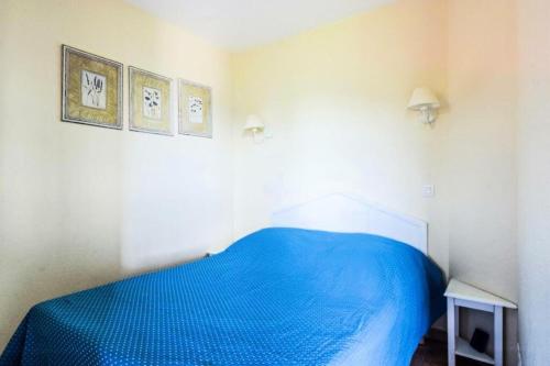 - une chambre avec un lit bleu dans l'établissement Résidence le Hameau des Issambres - maeva Home - Appartement 2 pièces 5 personnes Prestige MAE-1494, aux Issambres
