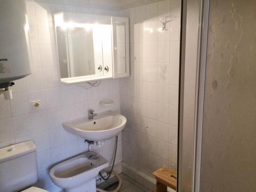 a white bathroom with a sink and a toilet at Résidence Plane - Studio pour 4 Personnes 574 in Montgenèvre