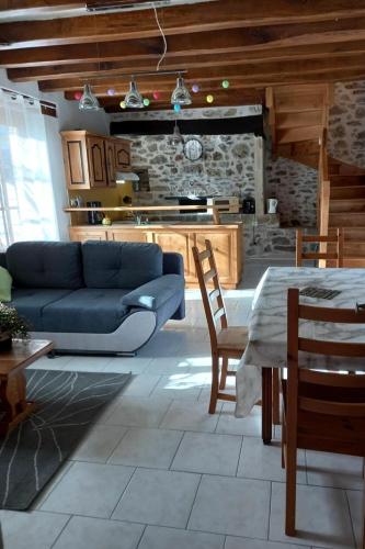 ein Wohnzimmer mit einem blauen Sofa und einem Tisch in der Unterkunft PEYRIGNAC - Maison 3 Pièces 4 personnes 684 in Peyrignac
