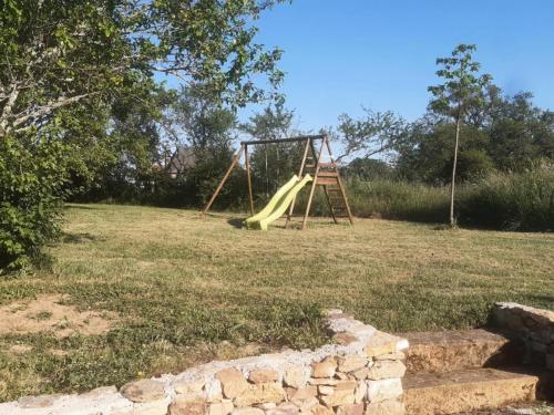 a playground with a slide in a field at PEYRIGNAC - Maison 3 Pièces 4 personnes 684 in Peyrignac