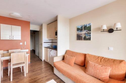 un salon avec un canapé orange et une cuisine dans l'établissement Résidence Cannes Villa Francia - maeva Home - Appartement 2 pièces 5 personnes - Budget MAE-0634, à Cannes