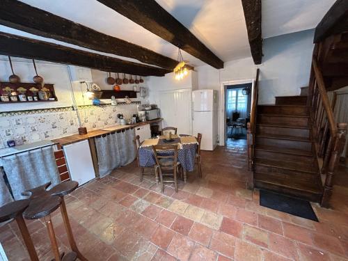 kuchnia ze stołem i krzesłami w pokoju w obiekcie Maison dans la magnifique village de Montjoi w mieście Monjoi