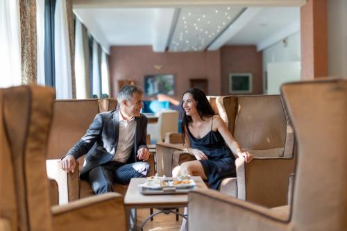 a man and a woman sitting in chairs at Hotel Terme Milano in Abano Terme