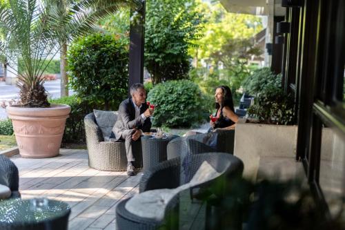 a couple of people sitting on a patio at Hotel Terme Milano in Abano Terme