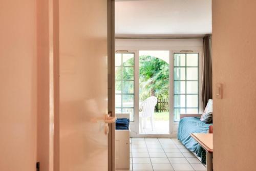 une pièce avec une porte ouverte sur une pièce avec un lit dans l'établissement Village Moliets - maeva Home - Studio 5 personnes - Budget MAE-4984, à Moliets-et-Maa