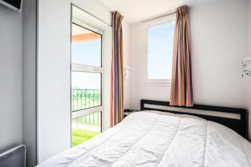 une chambre avec un lit et une grande fenêtre dans l'établissement Résidence le Village de Cap Esterel - maeva Home - Appartement 2 pièces 5 personnes vue mer - Prestige - Super Home MAE-5574, à Saint-Raphaël