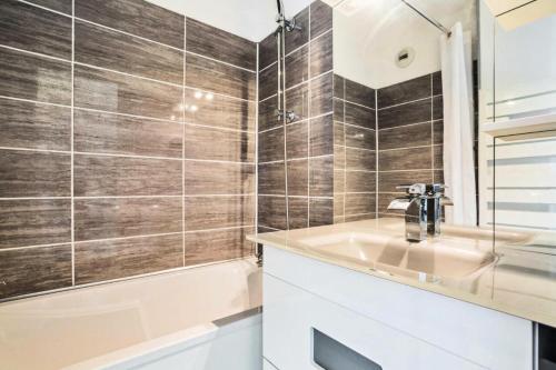une salle de bain avec un lavabo et une baignoire dans l'établissement Résidence le Village de Cap Esterel - maeva Home - Appartement 2 pièces 5 personnes vue mer - Prestige - Super Home MAE-5574, à Saint-Raphaël